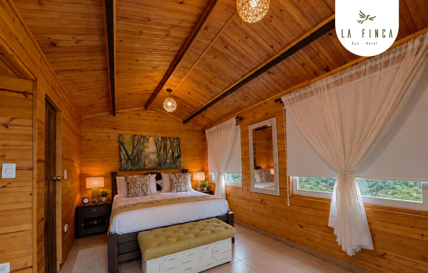 Habitación de la Cabaña 01 en el nivel superior, con cama doble bajo el techo de madera