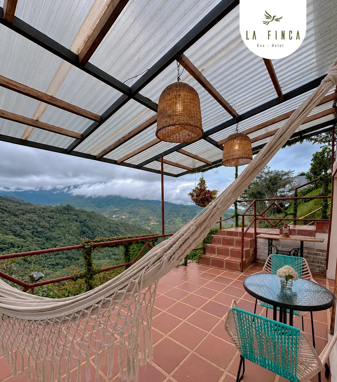 Balcón de la Cabaña 01 con hamaca, mesa para dos y vista al bosque de niebla