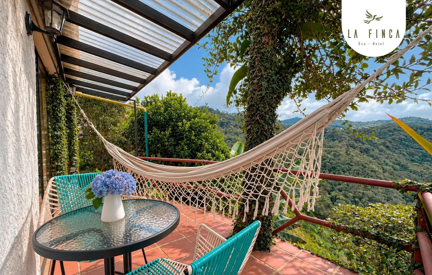 Terraza de la Cabaña 02 con hamaca, mesa para dos y vista a las montañas