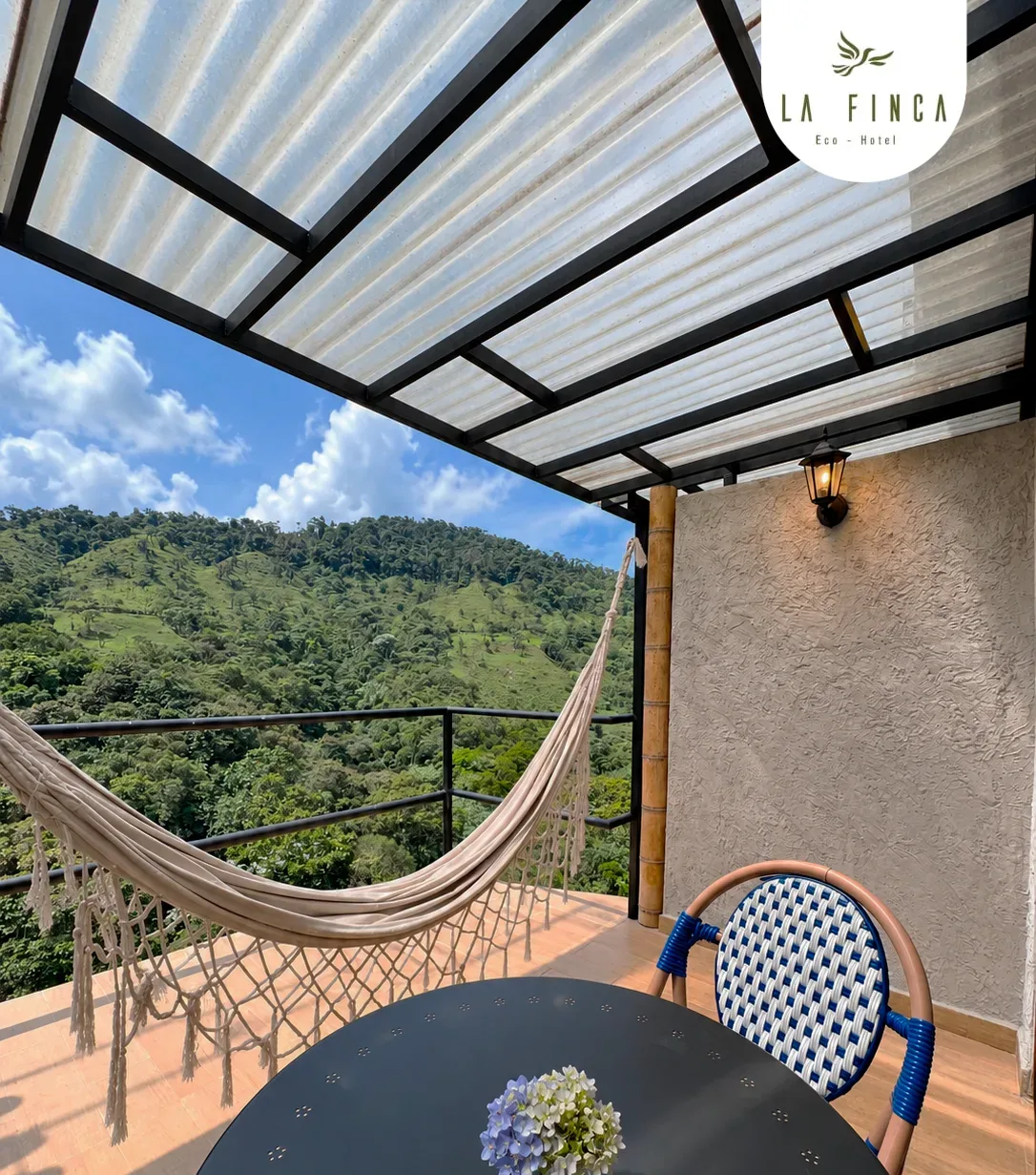 Comedor en el balcón de la Cabaña 03, con hamaca y vista al valle