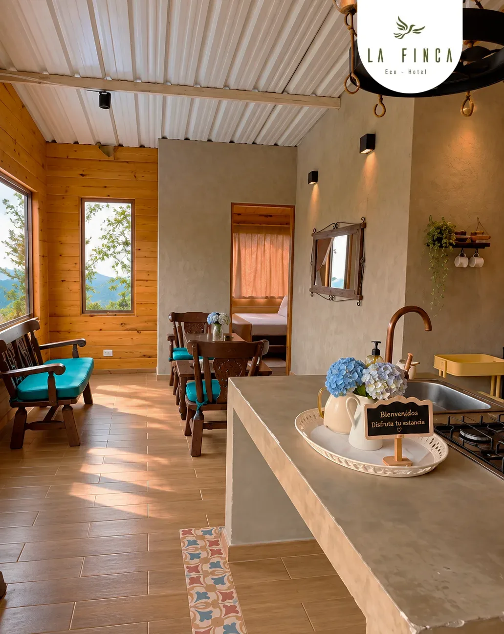 Sala y cocina de la Cabaña 05, con barra de piedra y ventanal al bosque